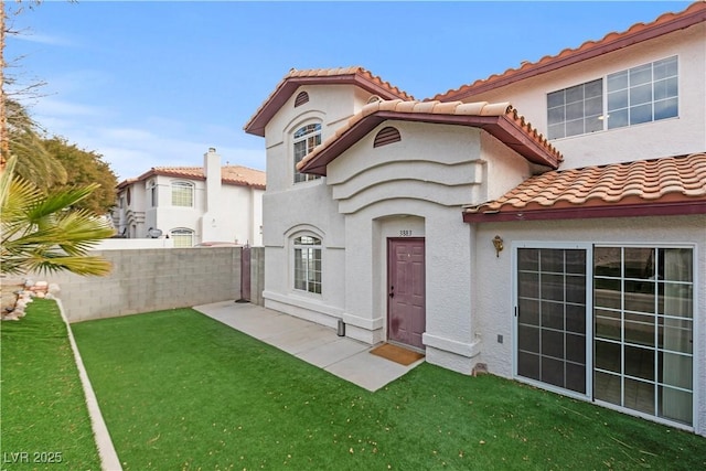 rear view of house featuring a yard and a patio area