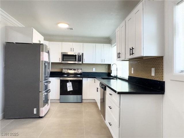 kitchen featuring stainless steel appliances, white cabinetry, and sink