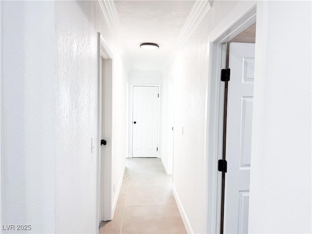 hallway with light tile patterned floors and crown molding