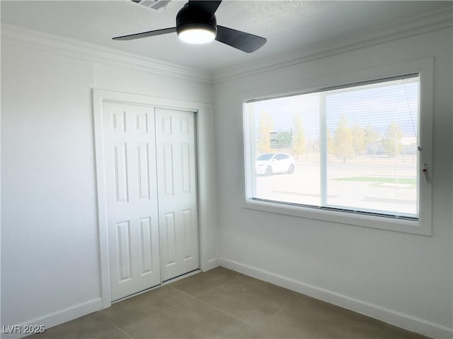 unfurnished bedroom featuring ceiling fan, ornamental molding, a closet, and light tile patterned floors