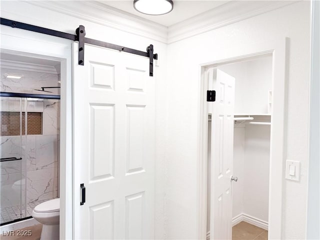 bathroom featuring crown molding, toilet, and a shower with door