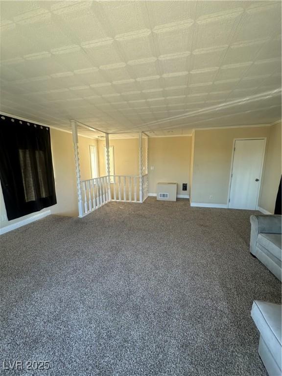 empty room with carpet floors, baseboards, and visible vents