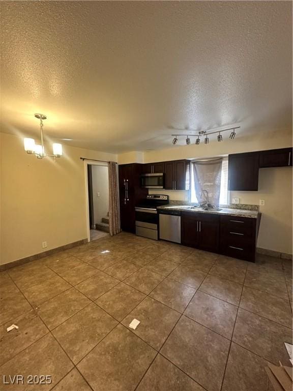 kitchen with an inviting chandelier, appliances with stainless steel finishes, a sink, a textured ceiling, and dark brown cabinets