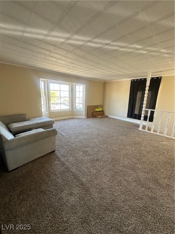 unfurnished living room featuring baseboards and carpet flooring