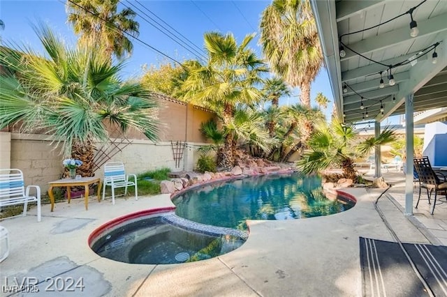 view of swimming pool with a patio and an in ground hot tub