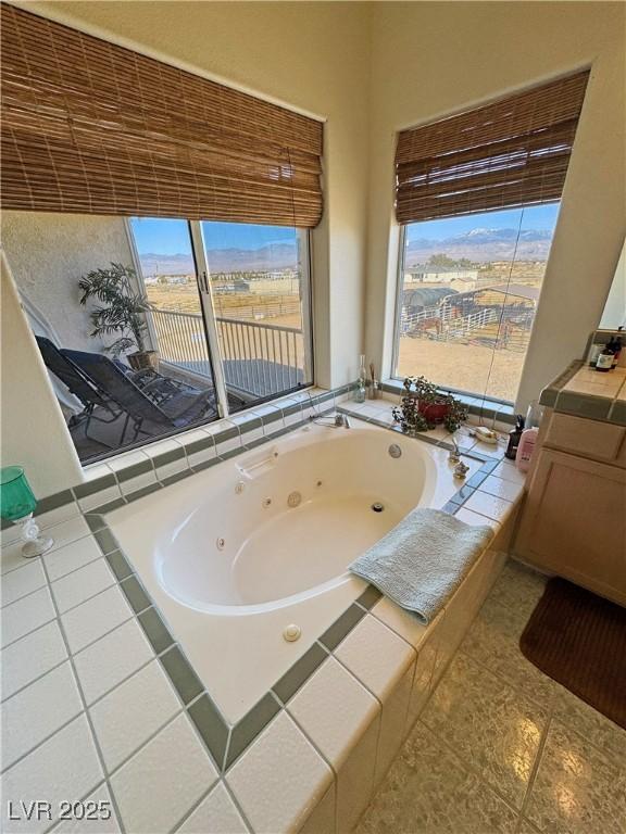 bathroom with plenty of natural light and tiled bath