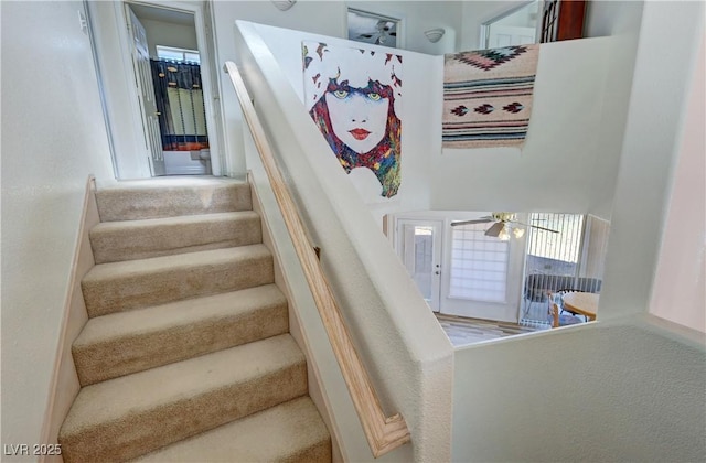 stairway with plenty of natural light and ceiling fan