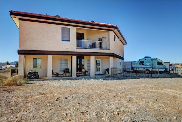 back of house with a balcony and a patio area