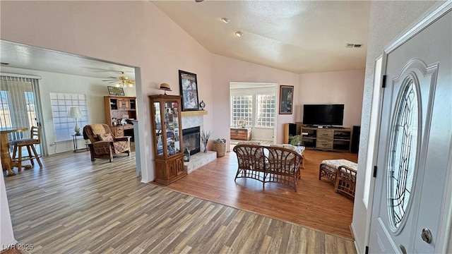 living room featuring hardwood / wood-style floors, vaulted ceiling, and ceiling fan