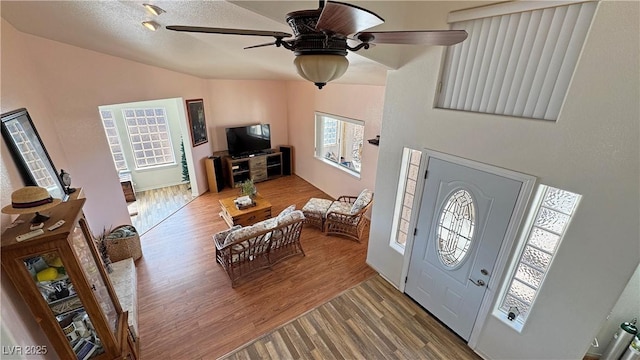 entrance foyer with lofted ceiling, wood-type flooring, and ceiling fan