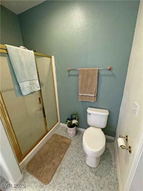 bathroom featuring tile patterned flooring, toilet, and walk in shower