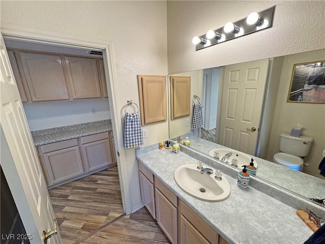 bathroom with wood-type flooring, vanity, and toilet