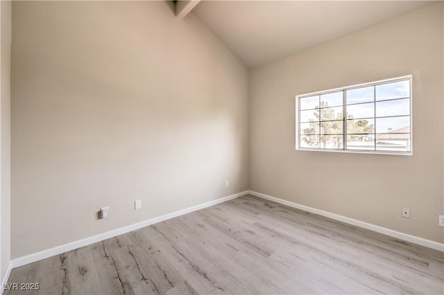 spare room with vaulted ceiling with beams and light hardwood / wood-style floors