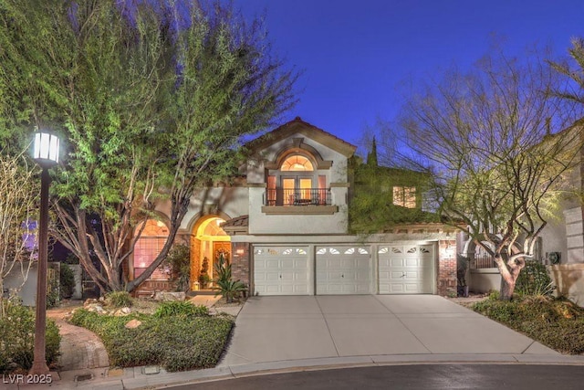 mediterranean / spanish-style home featuring a garage and a balcony