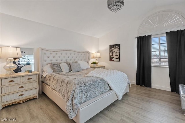 bedroom with lofted ceiling and light hardwood / wood-style flooring