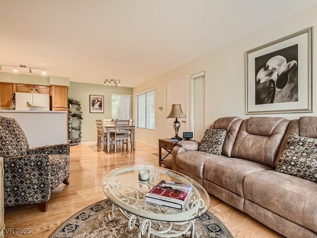 3055 Key Largo Dr Unit 203, Las Vegas, NV 89120 - living area with light wood finished floors, baseboards, and rail lighting