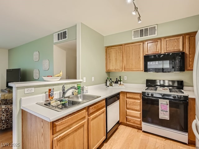 kitchen featuring sink, light hardwood / wood-style flooring, dishwasher, range with gas cooktop, and kitchen peninsula