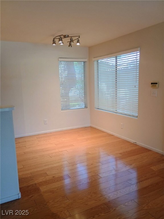 3055 Key Largo Dr Unit 203, Las Vegas, NV 89120 - spare room featuring track lighting, wood finished floors, and baseboards