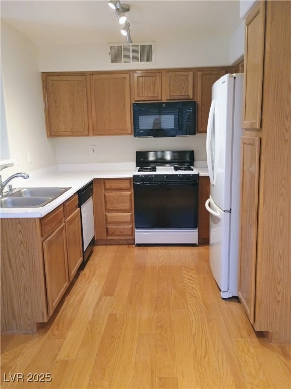 3055 Key Largo Dr Unit 203, Las Vegas, NV 89120 - kitchen with white appliances, a sink, light wood finished floors, and light countertops
