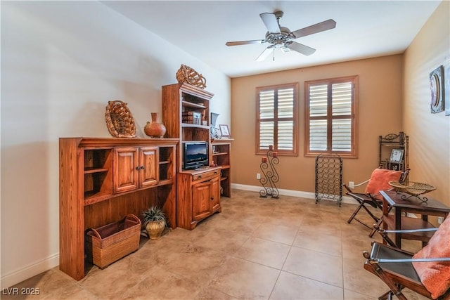 living area with a ceiling fan, baseboards, and light tile patterned floors