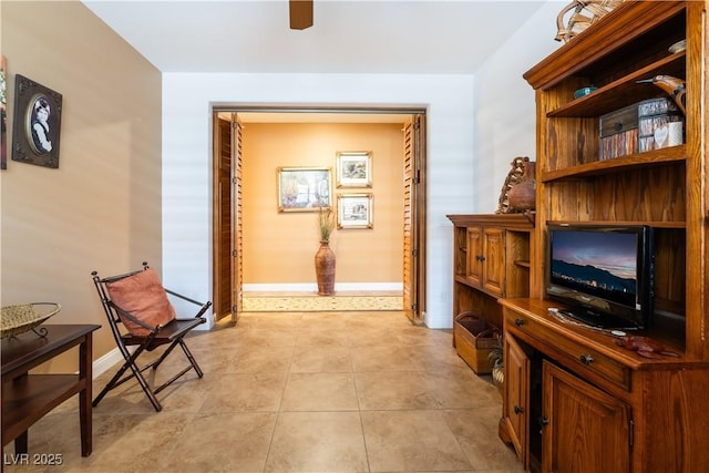 hallway featuring light tile patterned floors and baseboards