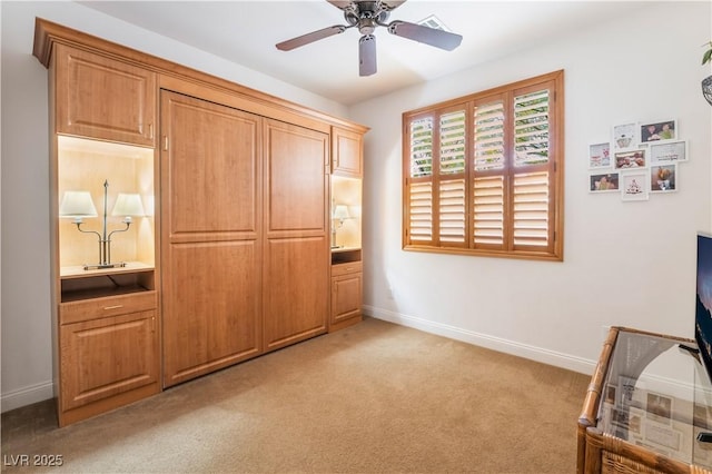 bedroom with baseboards, ceiling fan, ensuite bath, and light colored carpet