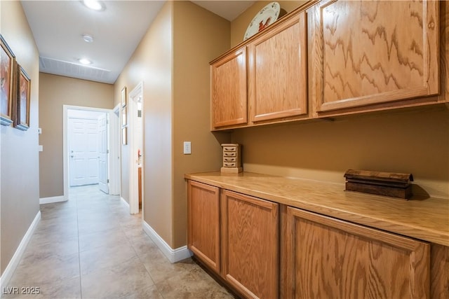 hallway with baseboards and light tile patterned floors