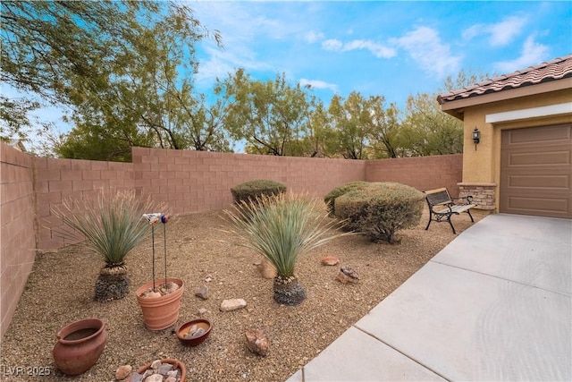 view of yard featuring a garage and a fenced backyard