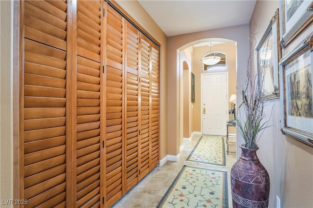 entryway featuring arched walkways and baseboards