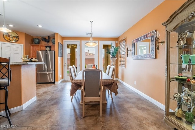 tiled dining room featuring baseboards and recessed lighting