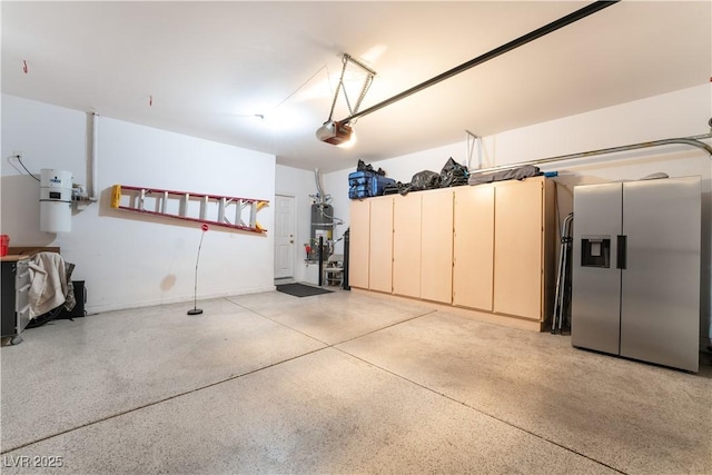 garage with a garage door opener, secured water heater, and stainless steel refrigerator with ice dispenser