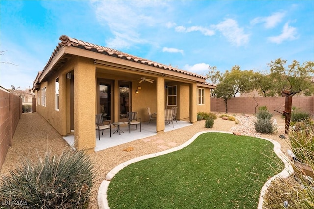 back of house with a patio area, a fenced backyard, ceiling fan, and stucco siding