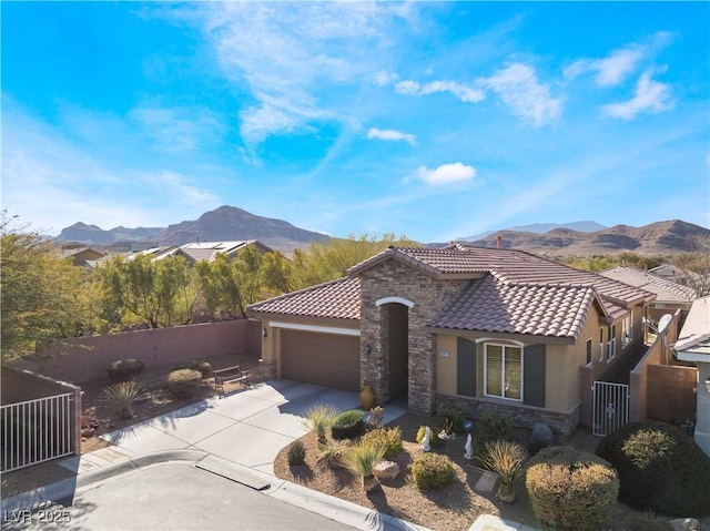 mediterranean / spanish house with stone siding, a mountain view, a tiled roof, and stucco siding