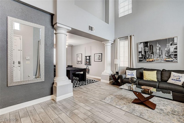 living room featuring a high ceiling and ornate columns