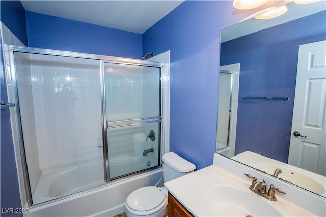 full bathroom featuring vanity, combined bath / shower with glass door, and toilet