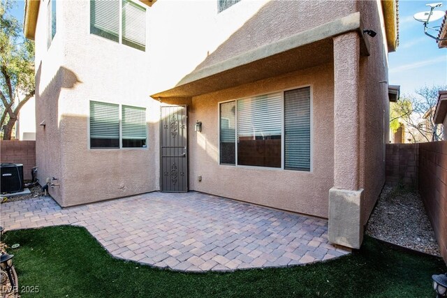 rear view of property featuring cooling unit and a patio