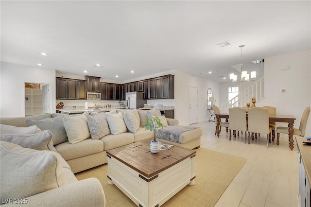 living room featuring a chandelier and light wood-type flooring