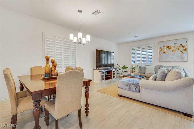 dining area featuring light hardwood / wood-style flooring and a notable chandelier