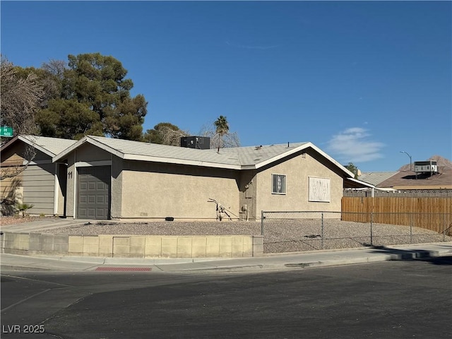 view of front of house with a garage and central AC