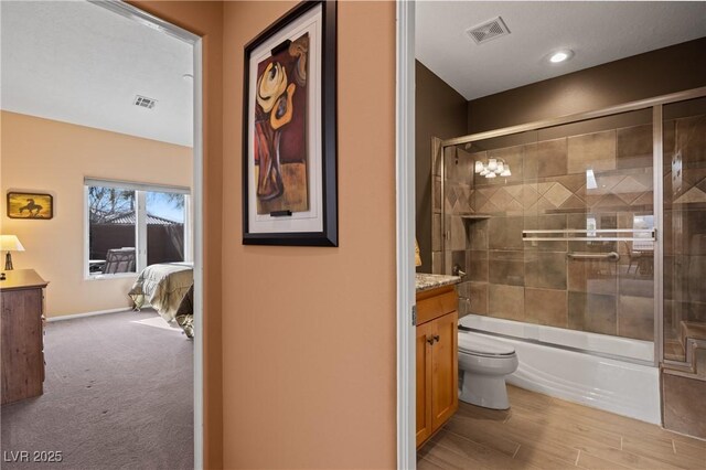 full bathroom with vanity, toilet, combined bath / shower with glass door, and hardwood / wood-style floors