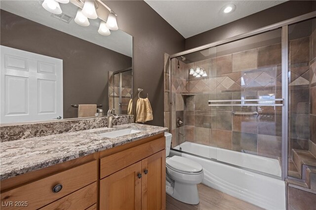 full bathroom featuring vanity, toilet, and combined bath / shower with glass door