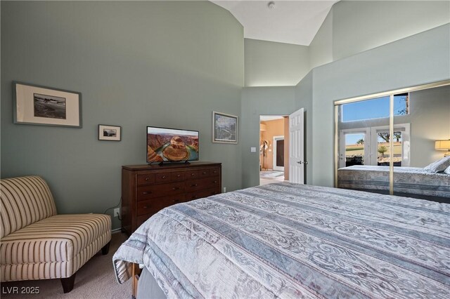 carpeted bedroom featuring high vaulted ceiling and a closet