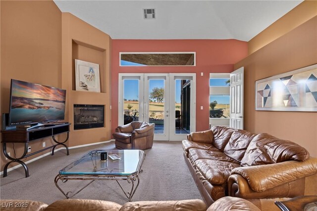 carpeted living room with lofted ceiling and french doors