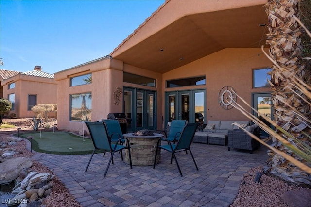 view of patio with a grill and an outdoor living space with a fire pit