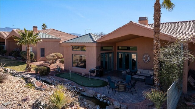 rear view of property with outdoor lounge area and a patio area