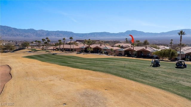 view of property's community with a mountain view and a lawn