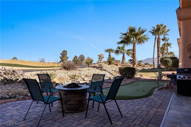 view of patio featuring a mountain view, a grill, and an outdoor fire pit