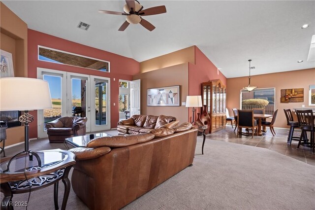 carpeted living room with french doors, ceiling fan, and vaulted ceiling