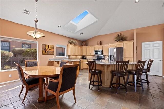 dining space with lofted ceiling with skylight