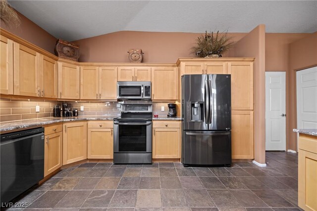 kitchen with lofted ceiling, stainless steel appliances, light stone counters, tasteful backsplash, and light brown cabinetry